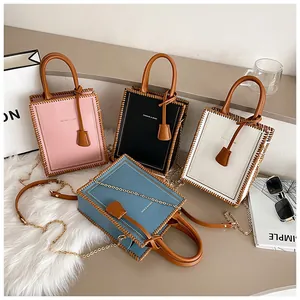 Close-up of four colors of faux leather tote bags with woven edge stitching and chain straps