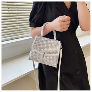 Detailaufnahme einer weißen Strass-Handtasche mit silbernem Metalldrehverschluss für Damen