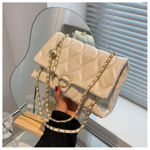Détail du sac matelassé blanc crème avec boucle en perles dorées et bandoulière