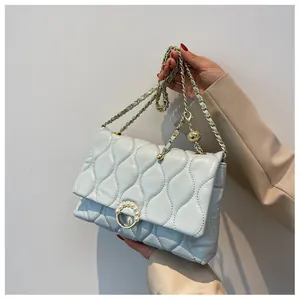 Détail du sac bandoulière matelassé bleu clair avec boucle perle et chaîne dorée