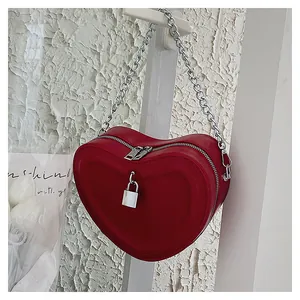 Detail of red heart-shaped purse with silver metal padlock and chunky chain strap