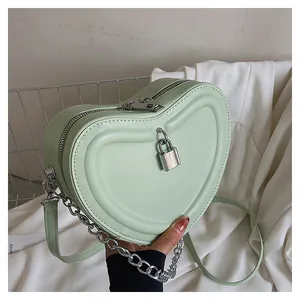 Close-up of heart-shaped mini crossbody bag in mint green leather with silver padlock