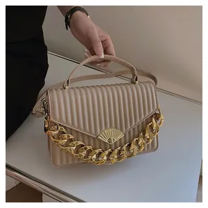 Detail der beigen Plissee-Handtasche mit goldener Kette und fächerförmigem Verschluss