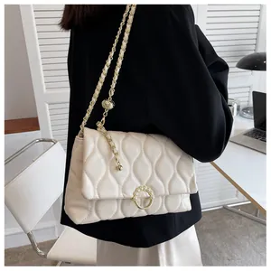 Détail du sac bandoulière blanc matelassé avec boucle perle et chaîne dorée