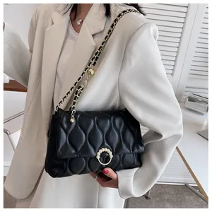 Détail du sac bandoulière matelassé noir avec fermoir perlé doré et bandoulière chaîne