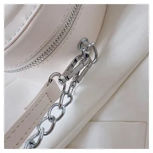 Detail of silver metal zipper and chain strap on stylish beige leather round mini bag