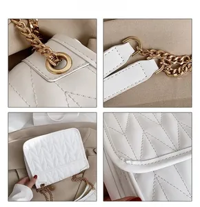 Detail view of white quilted shoulder bag with V-shaped stitching and gold chain strap