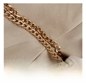 Close-up of golden metal chain and quilted white leather on a stylish shoulder bag