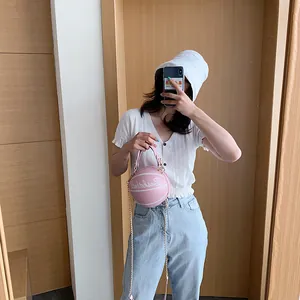 Sac à bandoulière rose en forme de basket avec chaîne dorée et lettrage blanc