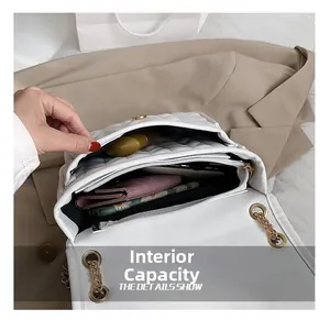 Internal view of white quilted crossbody bag showing compartments with phone and lipstick
