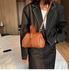 Détail d'un sac à main marron caramel texturé avec fermoir en métal et bandoulière
