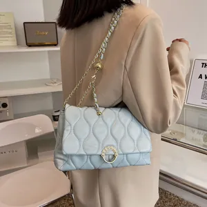 Sac bandoulière matelassé bleu clair avec chaîne dorée et boucle perle au style élégant