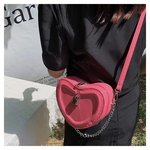 Detail of pink heart-shaped quilted bag with silver padlock and chain shoulder strap
