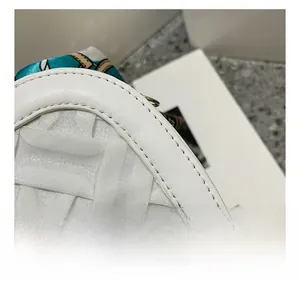 Detailed close-up showing precise stitching and leather texture of white woven handbag