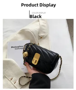 Détail d'un petit sac bandoulière noir matelassé avec chaîne dorée et coutures en V