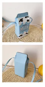 Detail view of a funny milk carton crossbody bag with cow print and 100% milk text