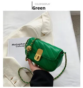 Détail du sac matelassé vert avec bandoulière en chaîne dorée et pendentif boule