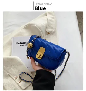 Détail du petit sac bleu matelassé avec chaîne dorée et fermoir rotatif chic