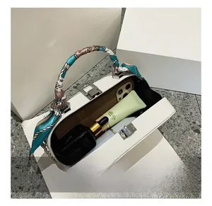 Detail showing the internal capacity of the white leather bag with phone and cosmetics