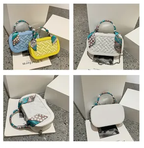 Detail of woven faux leather handbag with silk scarf handle and metal chain strap