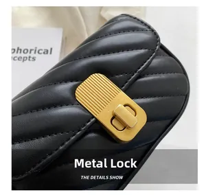Détail du fermoir doré en métal sur un petit sac bandoulière noir en cuir matelassé
