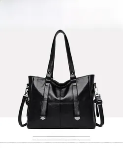 Detailed front view of black pebbled leather tote bag with dual handles and metal accents