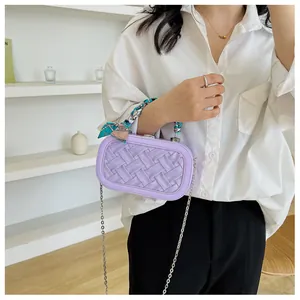 Detail of purple woven handbag featuring silver chain strap and silk scarf wrapped handle