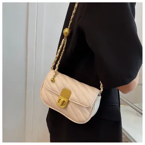 Détail du sac bandoulière matelassé crème avec fermoir doré et bandoulière chaîne