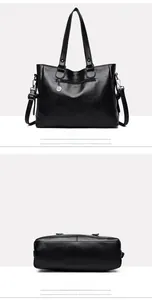 Detail view of black leather tote bag showing back zipper pocket and reinforced bottom base