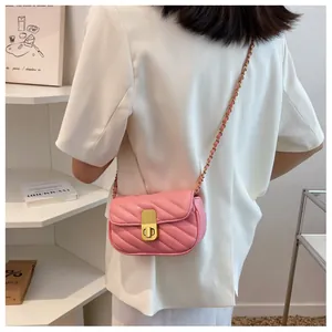 Détail du petit sac à bandoulière matelassé rose avec chaîne dorée porté par mannequin