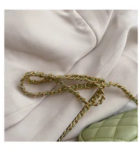Close-up of light green quilted leather handbag with gold-tone interwoven chain strap