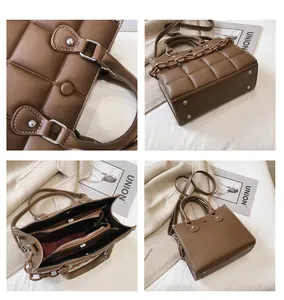 Detail of brown woven textured crossbody bag featuring metal studs and inner compartment