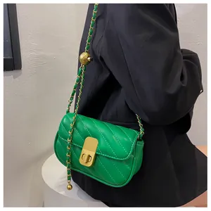 Détail du sac en cuir matelassé vert avec chaîne dorée et bille de réglage en métal