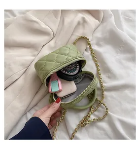 Detail view of mini green quilted box bag with gold chain strap and vanity storage
