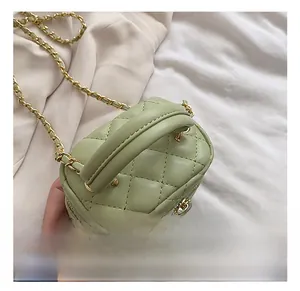 Detail of light green quilted mini box bag with gold chain strap and top handle
