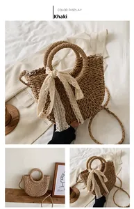 Détail d'un sac en paille tressée kaki avec nœud en dentelle blanche et anses rondes