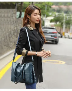 Detail of blue leather tote bag showing fine oily texture and adjustable shoulder strap