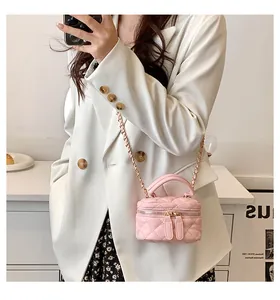 Detailed close-up of a pink quilted mini vanity bag with a gold chain strap and top handle