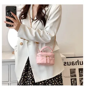 Mirror selfie showing the pink quilted mini vanity bag with golden chain strap