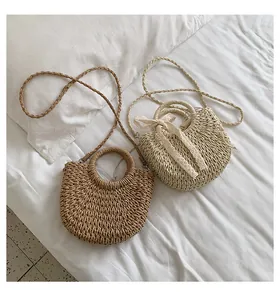 Détail du tissage de sacs en paille beiges et marron avec anses rondes élégantes