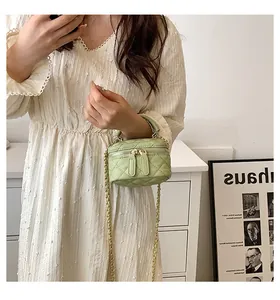 Mint green quilted mini vanity bag with gold chain strap shown on a female model