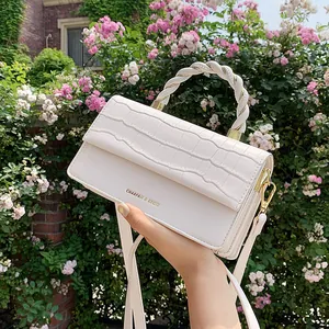 White faux leather crossbody bag with crocodile embossed flap and metal woven handle