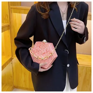 Detail van roze marmeren hexagon schoudertas met parelsluiting en gouden metalen ketting