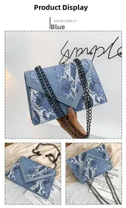Détail du sac enveloppe bleu motif serpent avec chaîne en métal et rabat en V
