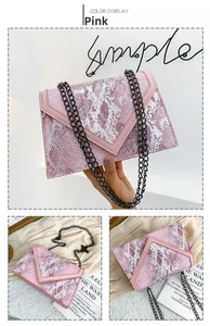 Détail de la pochette rose motif serpent avec bandoulière en chaîne métallique