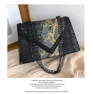 Détail de la texture serpent et du rabat en V sur ce petit sac à bandoulière tendance