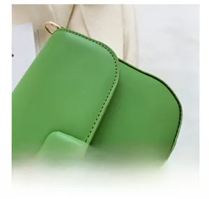 Detail view of the fine stitching and high-quality green leather texture on the bag