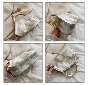 Detail view of marble pattern box bag featuring 3D bear relief and gold metal handle
