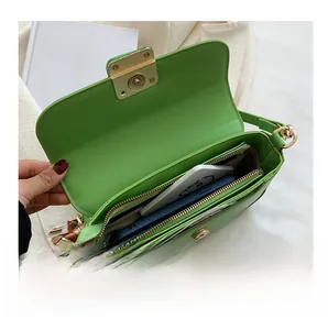 Detail showing the internal storage of a green PU leather bag with multi-layer zipper pockets