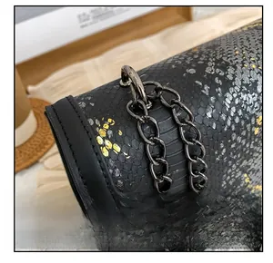 Détail du motif serpent gaufré et de la chaîne métallique sur le sac à main noir
